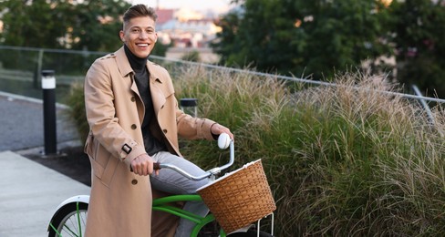 Photo of Happy man riding bicycle on city street. Space for text