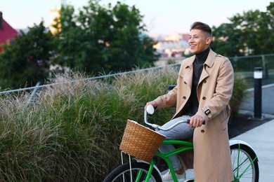 Photo of Happy man riding bicycle on city street. Space for text