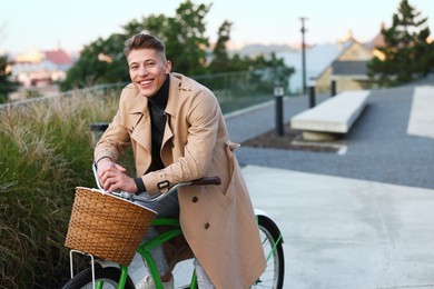 Photo of Happy man riding bicycle on city street. Space for text