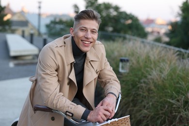 Photo of Happy man walking his bicycle on city street