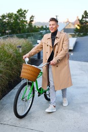 Photo of Happy man walking his bicycle on city street