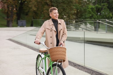 Photo of Happy man walking his bicycle on city street