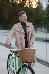 Photo of Happy man walking his bicycle on city street