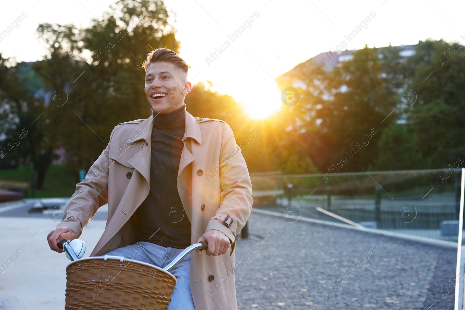 Photo of Happy man riding bicycle on city street. Space for text