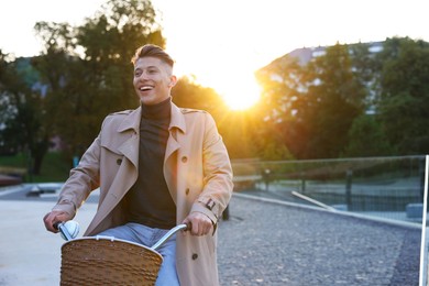 Photo of Happy man riding bicycle on city street. Space for text