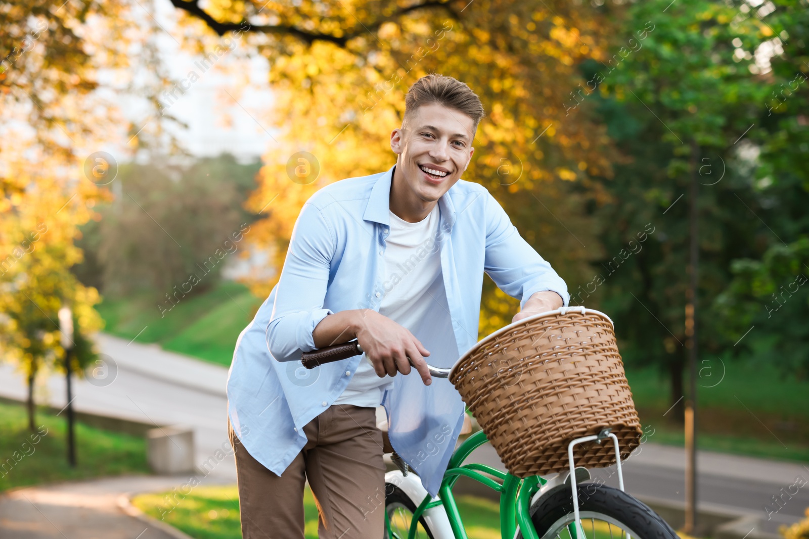 Photo of Happy man walking his bicycle in park on sunny day