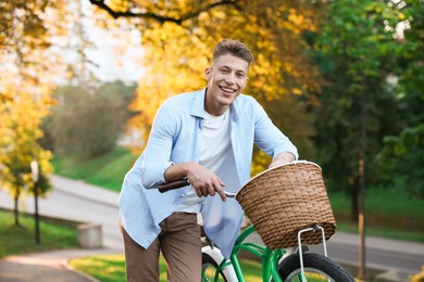 Photo of Happy man walking his bicycle in park on sunny day