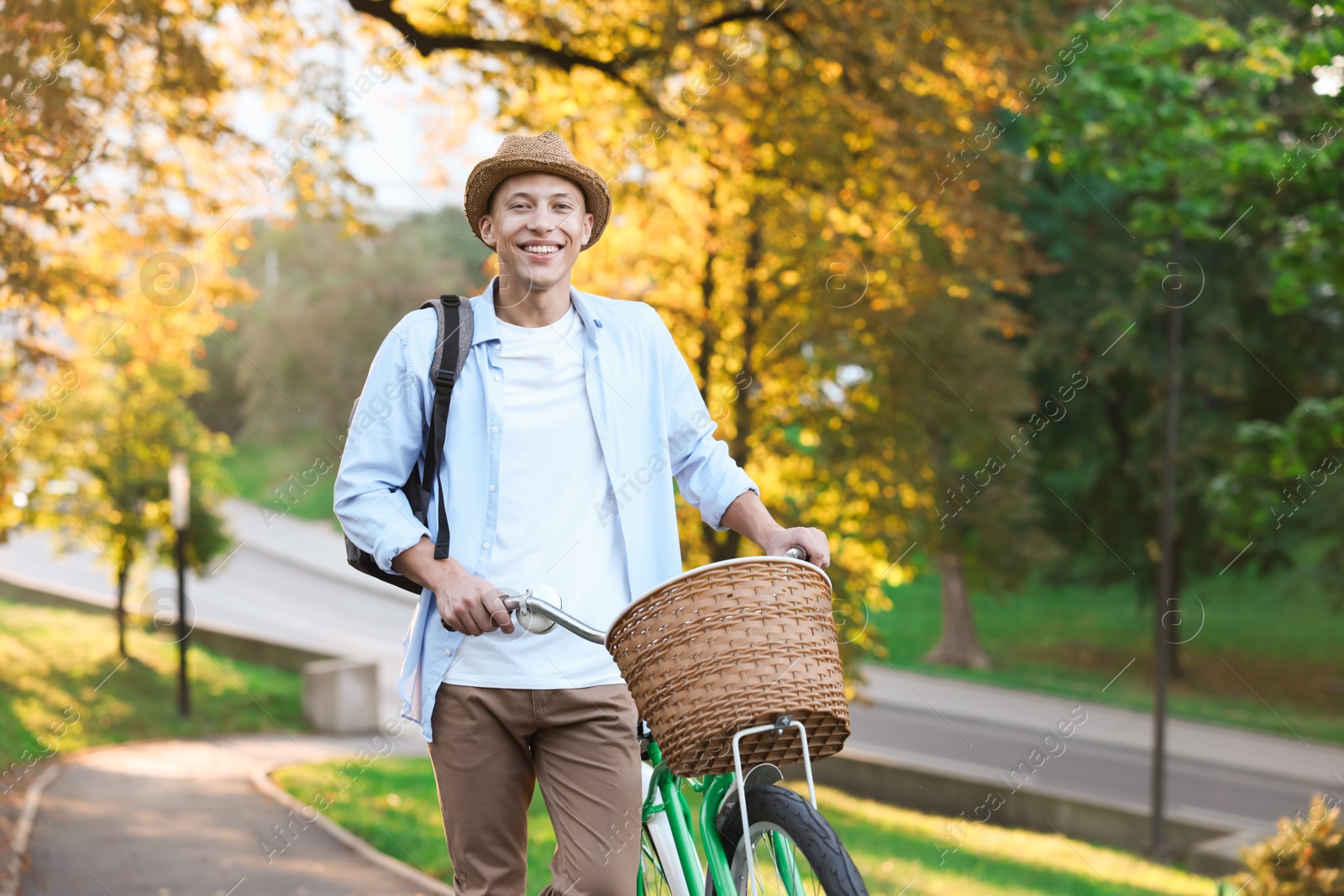 Photo of Happy man walking his bicycle in park on sunny day