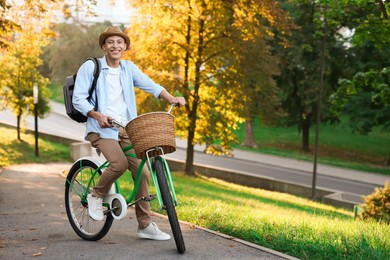 Photo of Happy man riding bicycle in park on sunny day. Space for text