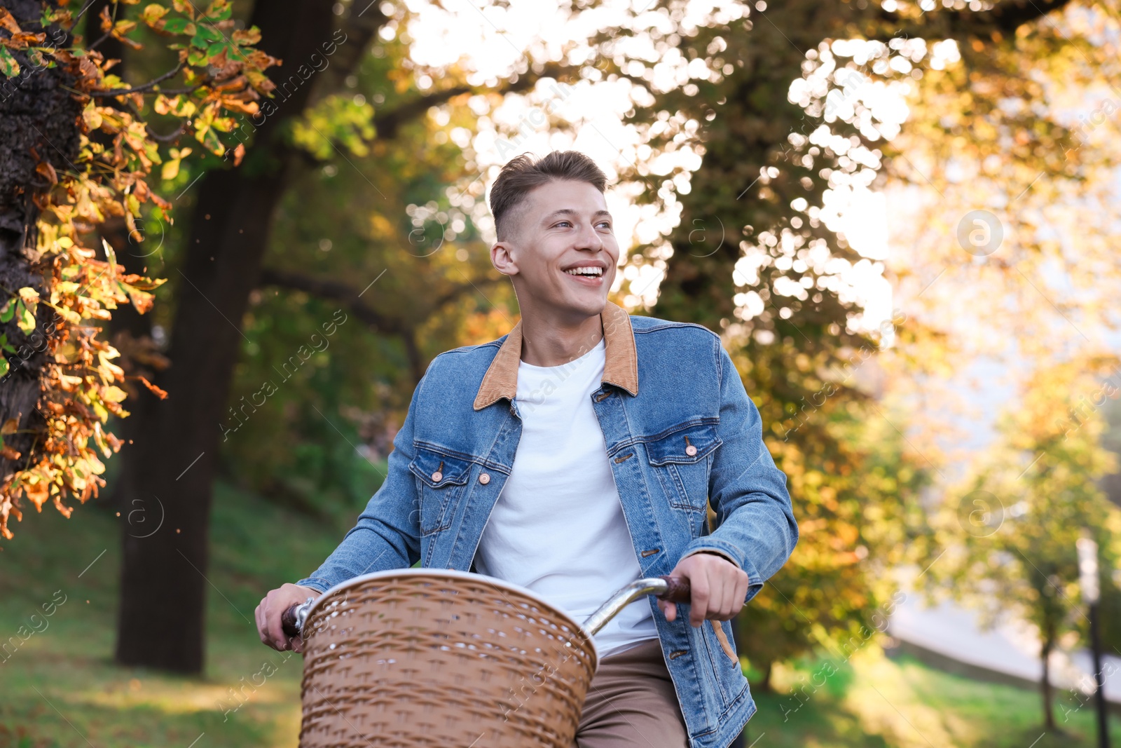 Photo of Happy man riding bicycle in park on sunny day