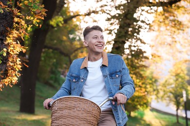 Photo of Happy man riding bicycle in park on sunny day