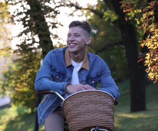 Photo of Happy man riding bicycle in park on sunny day
