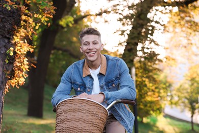 Photo of Happy man riding bicycle in park on sunny day