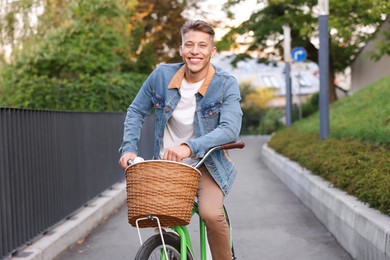 Photo of Happy man riding bicycle on city street