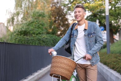 Photo of Happy man with backpack riding bicycle on city street. Space for text