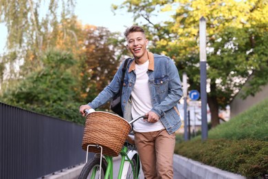 Photo of Happy man with backpack riding bicycle on city street