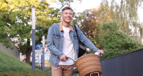 Photo of Happy man with backpack riding bicycle on city street