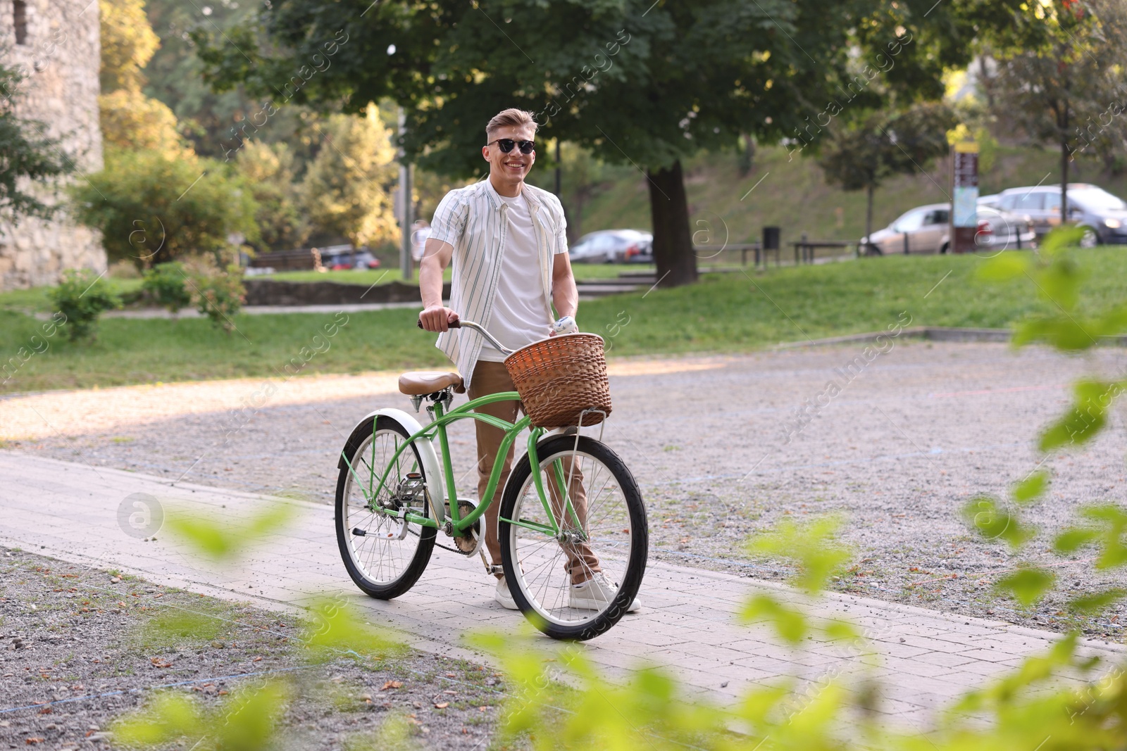 Photo of Happy man walking his bicycle on city street. Space for text