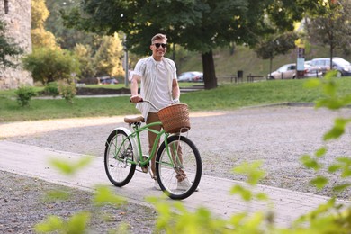 Photo of Happy man walking his bicycle on city street. Space for text