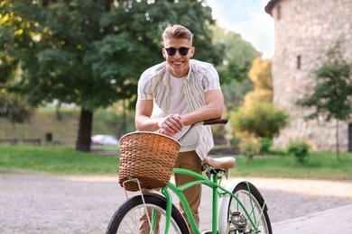 Photo of Happy man walking his bicycle on city street