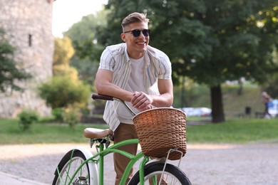 Photo of Happy man walking his bicycle on city street