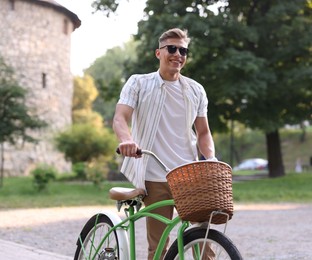 Photo of Happy man walking his bicycle on city street