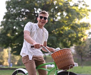 Photo of Happy man riding bicycle on city street