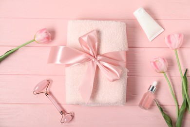 Photo of Fresh terry towel, hygiene products and tulips on pink wooden background, flat lay