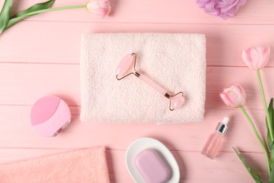 Photo of Fresh terry towels, hygiene products and tulips on pink wooden background, flat lay