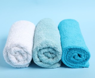 Photo of Fresh terry towels on light blue background