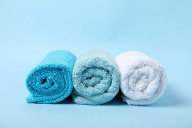 Photo of Fresh terry towels on light blue background