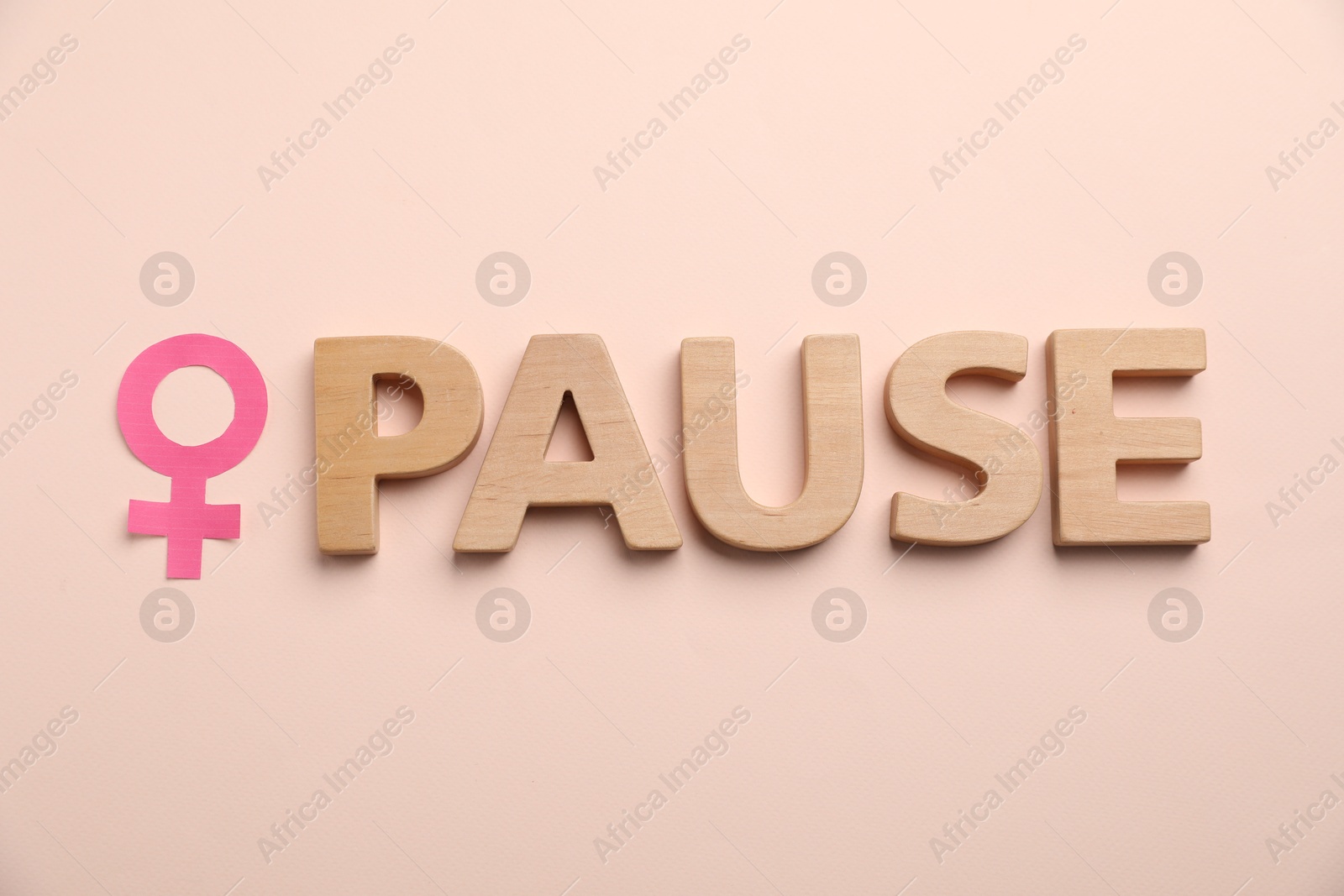 Photo of Word Pause and female gender symbol on beige background, top view