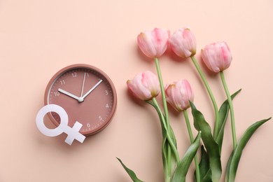 Photo of Menopause. Female gender symbol, alarm clock and tulips on beige background, flat lay