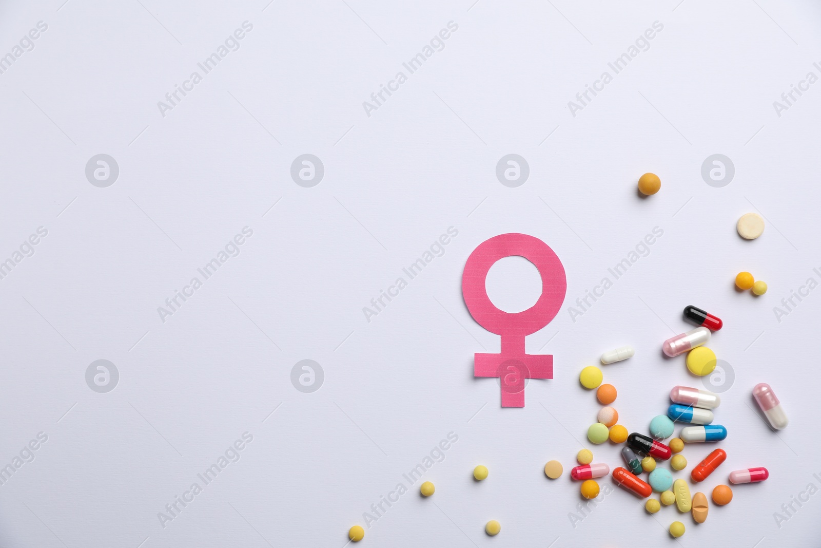 Photo of Menopause. Female gender symbol and pills on light background, flat lay. Space for text