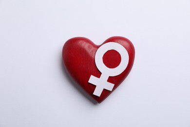 Photo of Menopause. Female gender symbol and wooden heart on light background, top view