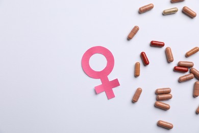 Photo of Menopause. Female gender symbol and pills on light background, flat lay. Space for text