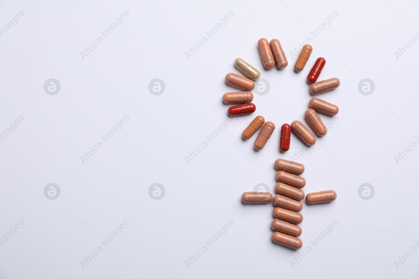 Photo of Menopause. Female gender symbol made with pills on light background, top view. Space for text
