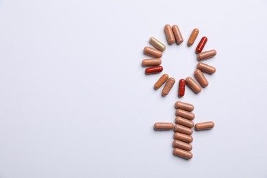 Photo of Menopause. Female gender symbol made with pills on light background, top view. Space for text
