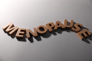 Photo of Word Menopause on light grey background, closeup