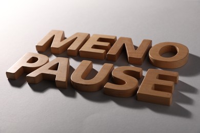 Photo of Word Menopause on light grey background, closeup