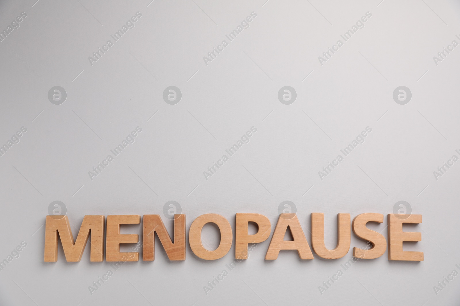 Photo of Word Menopause on light grey background, top view. Space for text