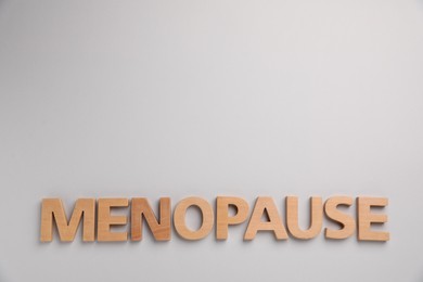 Photo of Word Menopause on light grey background, top view. Space for text