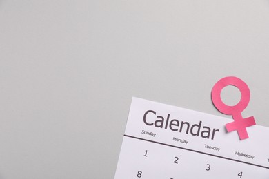 Photo of Menopause. Female gender symbol and calendar on light grey background, top view. Space for text