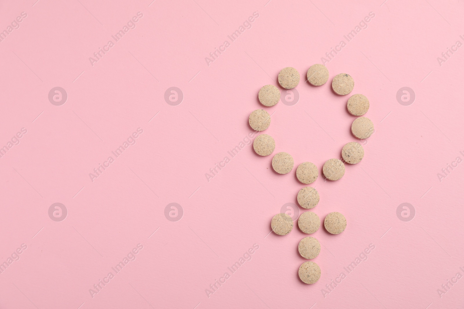 Photo of Menopause. Female gender symbol made with pills on pink background, top view. Space for text