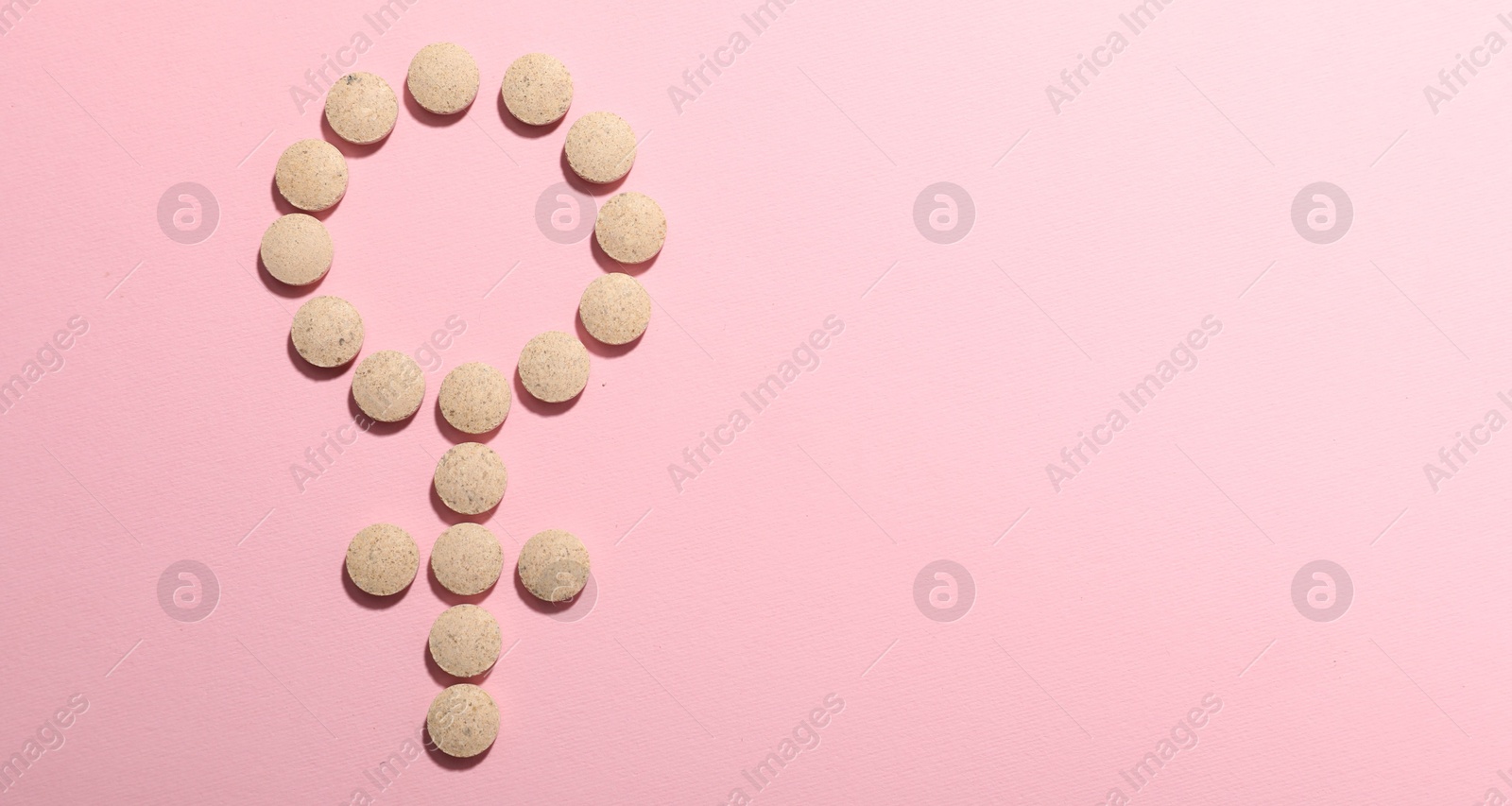 Photo of Menopause. Female gender symbol made with pills on pink background, top view. Space for text