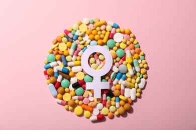 Photo of Menopause. Female gender symbol and pills on pink background, top view