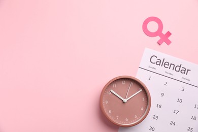 Photo of Menopause. Female gender symbol, alarm clock and calendar on pink background, flat lay. Space for text