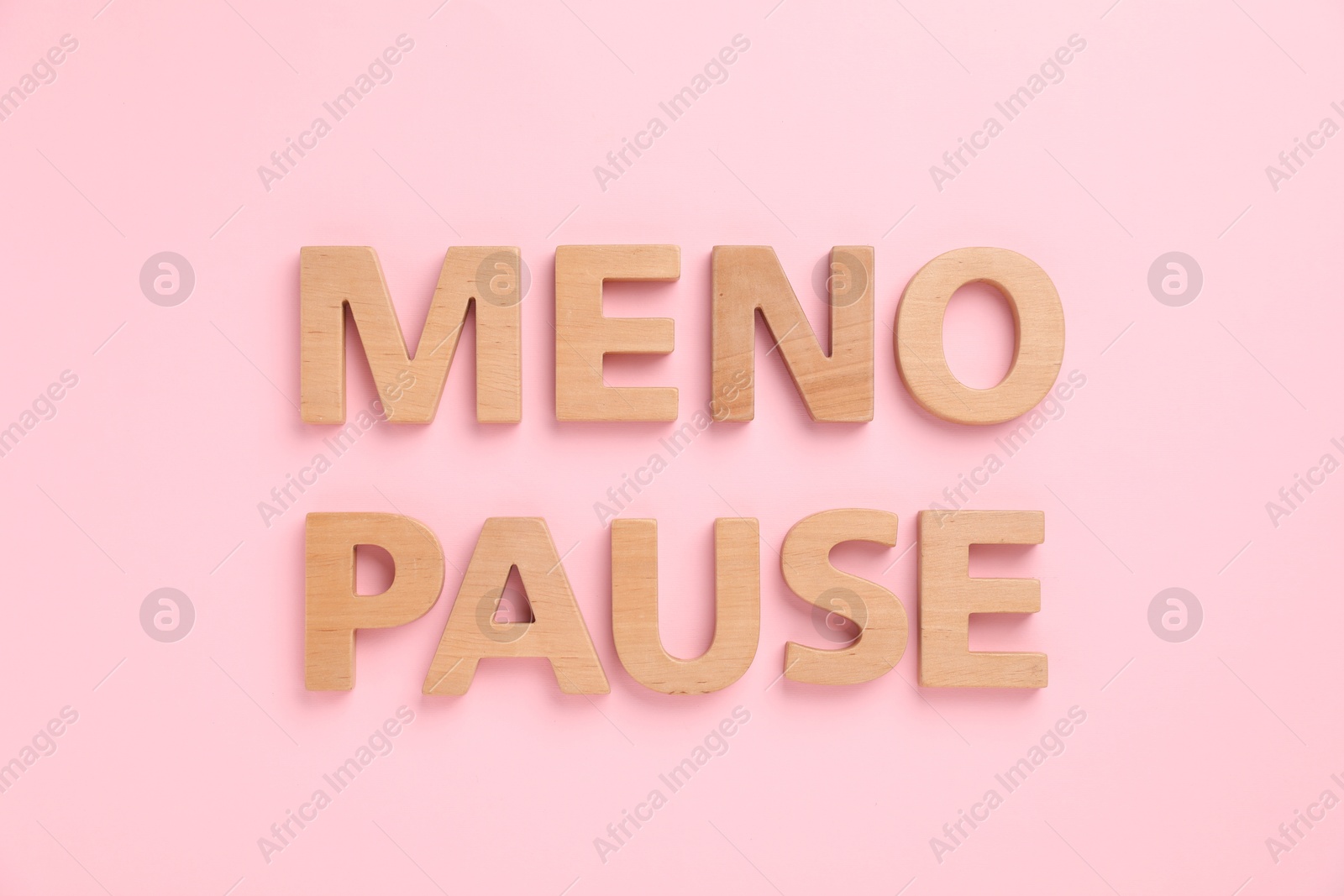 Photo of Word Menopause on pink background, top view