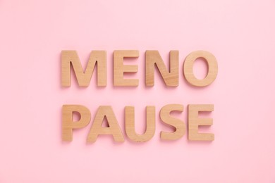 Photo of Word Menopause on pink background, top view
