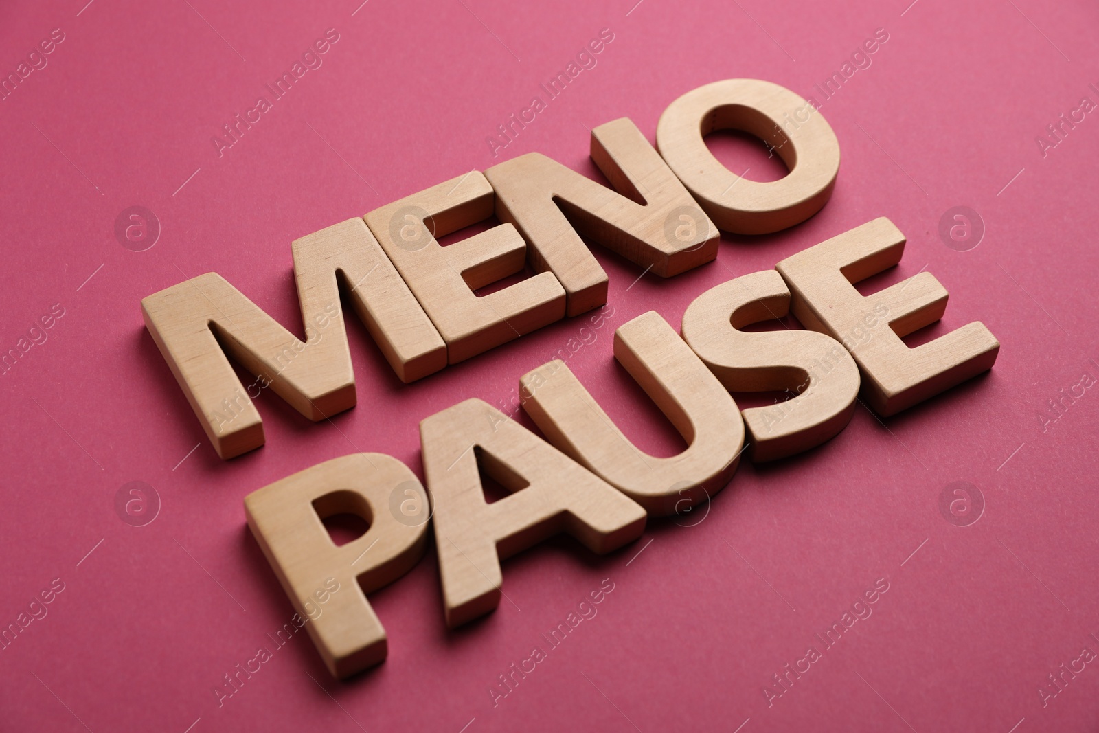 Photo of Word Menopause on crimson background, closeup view